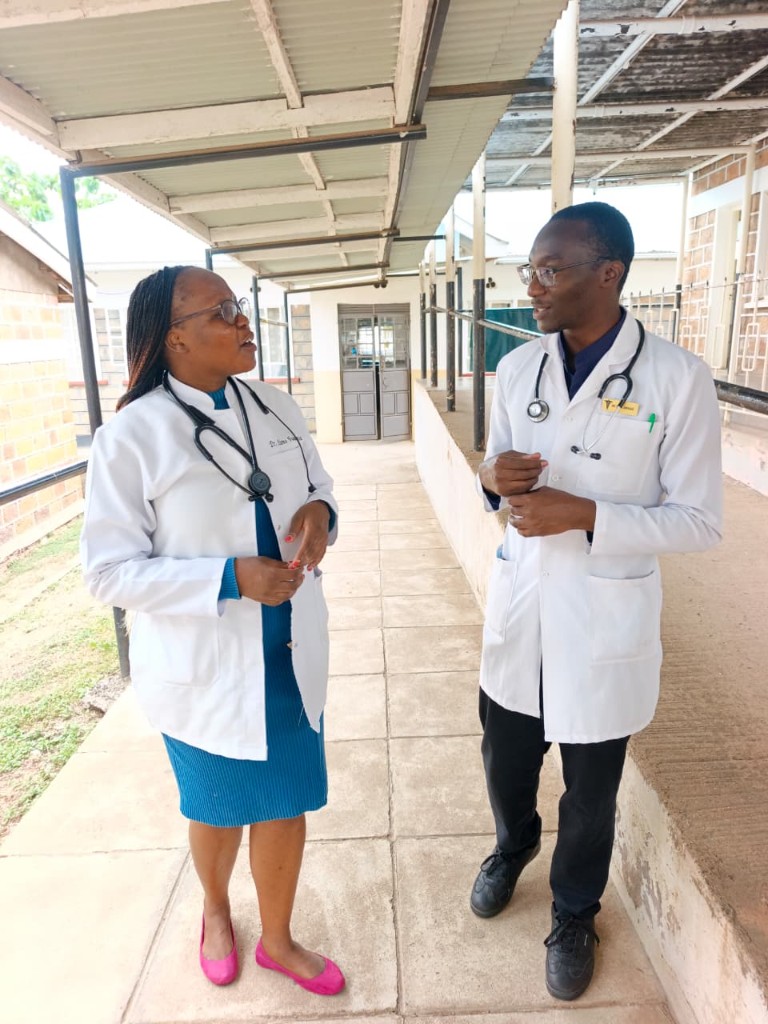 Clinicians in a covered walkway at the hospital